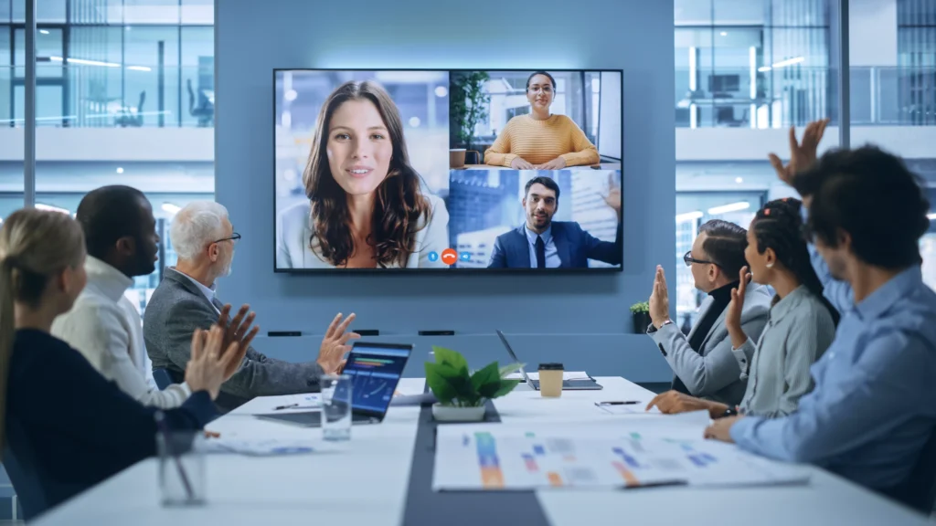Videoconferência na sala de reuniões da sede: os diretores executivos conversam com um grupo de empreendedores, gestores e investidores de diversas origens étnicas.